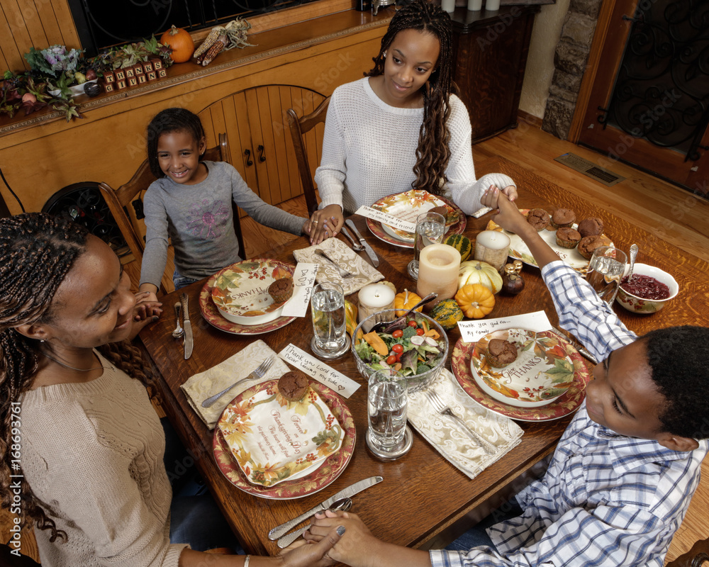 Thanksgiving family at dinner table from overhead, warm wood, classic table  setting Photos | Adobe Stock