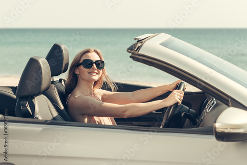 Young woman drive a car on the beach © fotofabrika