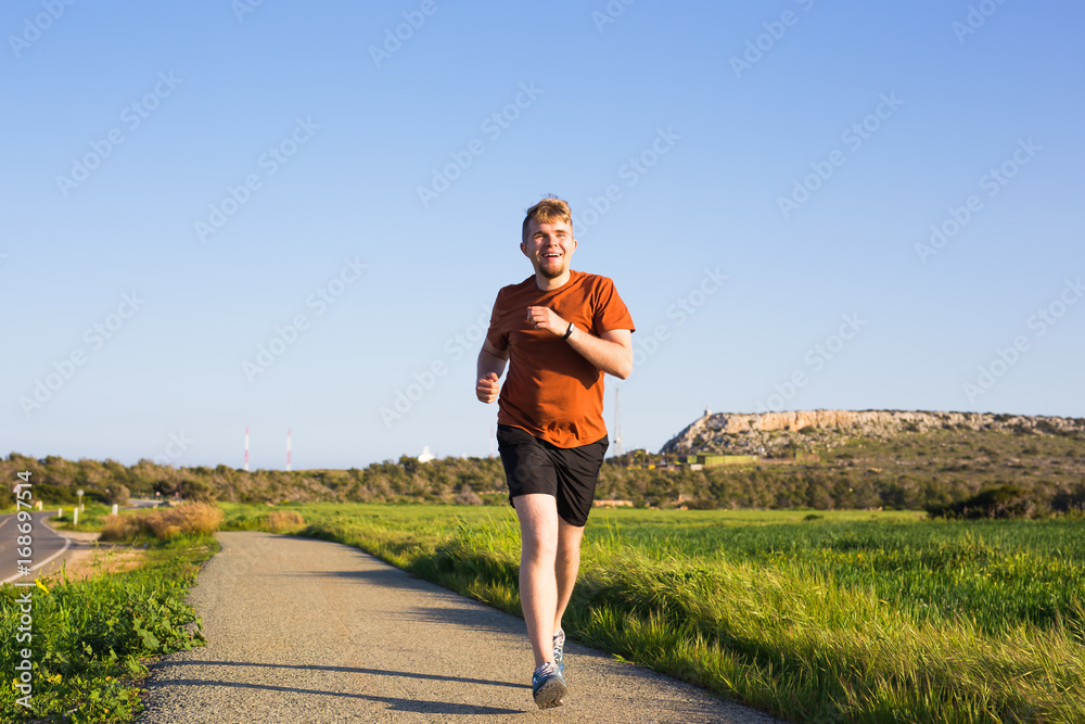 Man running outdoor sprinting for success. Male fitness runner sport athlete in sprint at great speed in beautiful landscape.