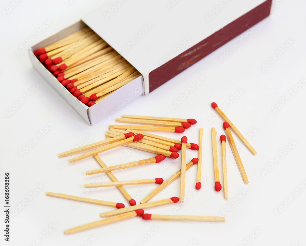 matchbox opened on white, pile match outside the box.
