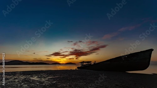 4-K Time lapse of shipwreck on beach in the andaman sea with beautiful sunrise or sunset in phuket thailand photo