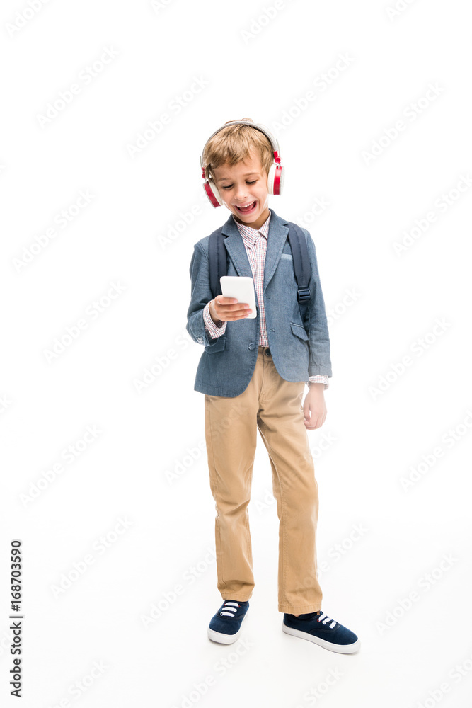 schoolboy using headphones and smartphone