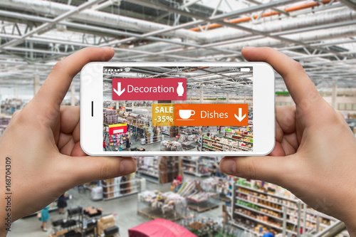 Augmented reality in marketing. Phone in hand, on screen information guide about goods and discounts in home center in real time photo