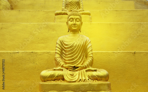 Buddha statue golden of Wat Phra That Chulamanee Sri Siam, Baan kormanae, Tambon Tha Song Yang Tak Province THAILAND with flog cloud, mountain and green trees background photo