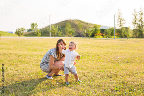 concept of family - mother and child son outdoors in summer