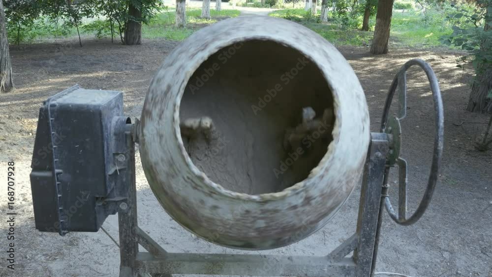 Portable concrete mixer spinning with concrete inside.
Portable concrete mixer spinning with concrete inside.