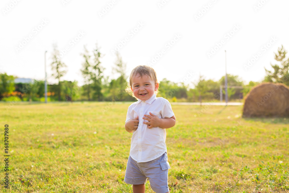 Happy laughing baby boy playing on summer or autumn field. Happy laughing baby boy playing on summer or autumn field.
