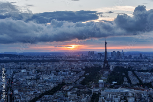 Scenic aerial view of Paris, France, from the Tour Montparnasse with the Eiffel Tower in the background at sunset. Colourful nighttime skyline. Travel background.