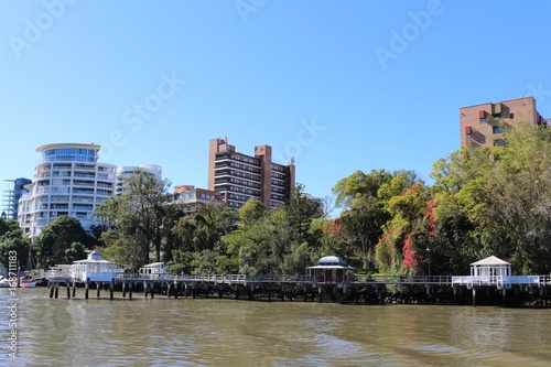 Riverside promenade with picturesque pavillions in front of modern apartment buildings