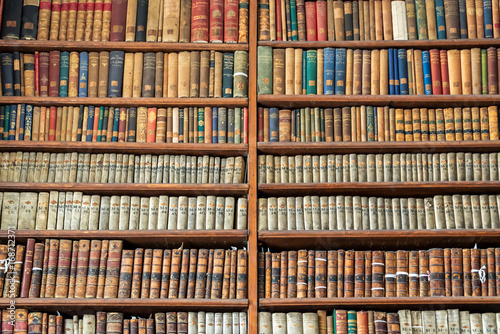 Background of old vintage books on wooden bookshelf in a library