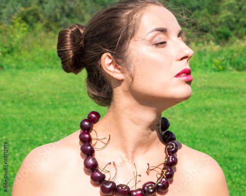 beautiful woman with beads made of fresh cherry photo