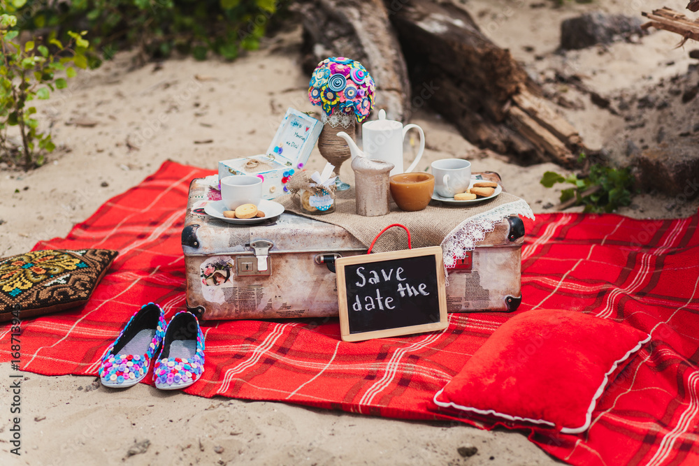 Romantic still life picnic on a beach. Cups, cookie, suitcase Romantic still life picnic on a beach. Cups, cookie, suitcase