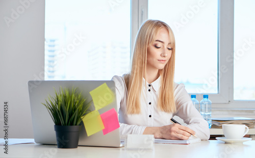 Beautiful young woman working at the computer in the office