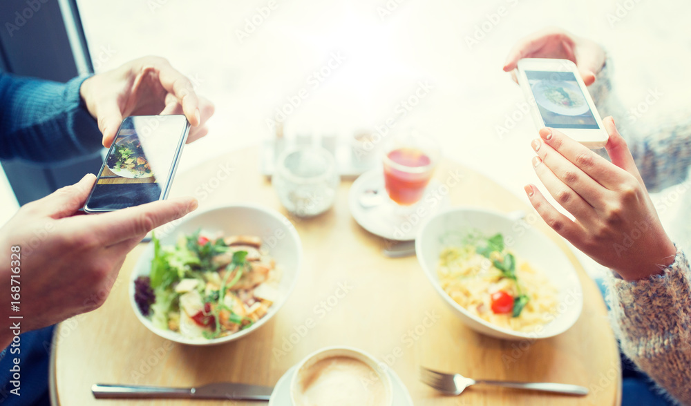 close up of couple picturing food by smartphone close up of couple picturing food by smartphone