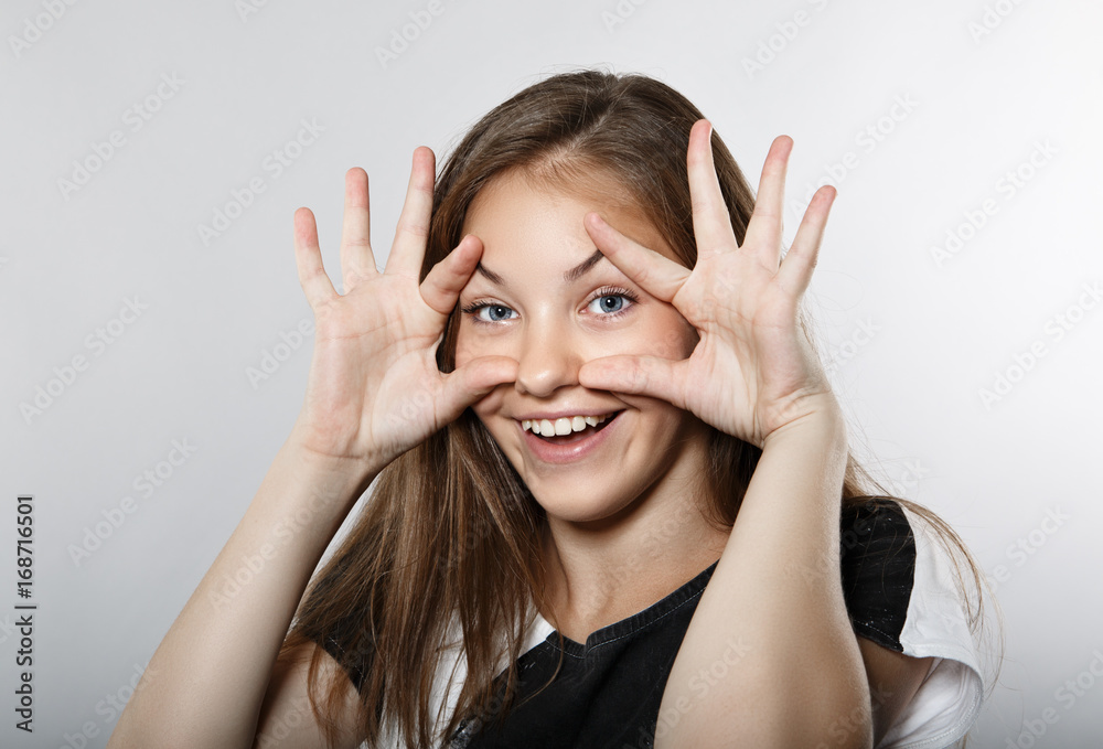 The funny girl opens her eyes with her hands. The girl laughs The funny girl opens her eyes with her hands. The girl laughs