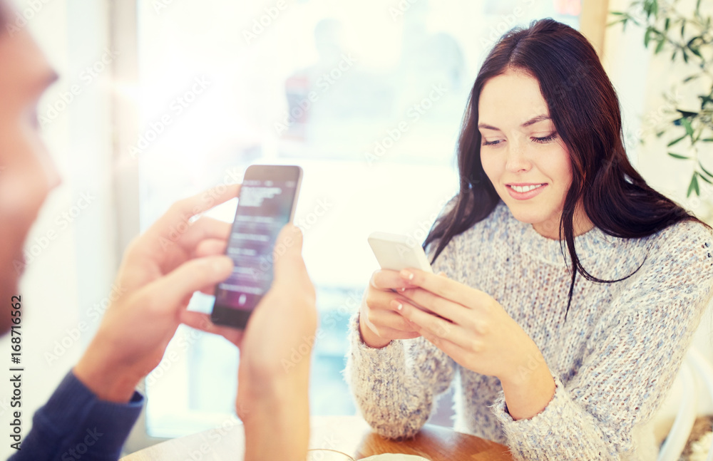 happy couple with smartphones at cafe happy couple with smartphones at cafe