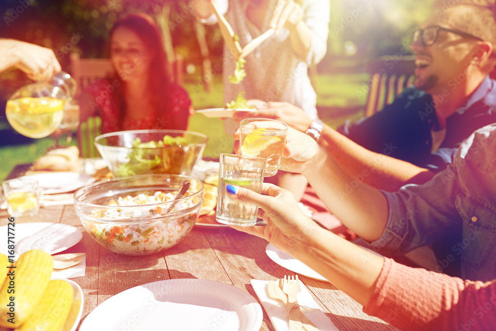 happy friends with drinks at summer garden party