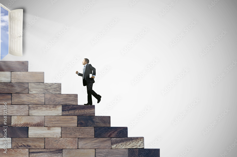 Businessman walking on stair wood to door of success