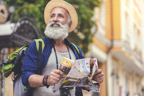 Joyful senior male traveler enjoying walk in town photo