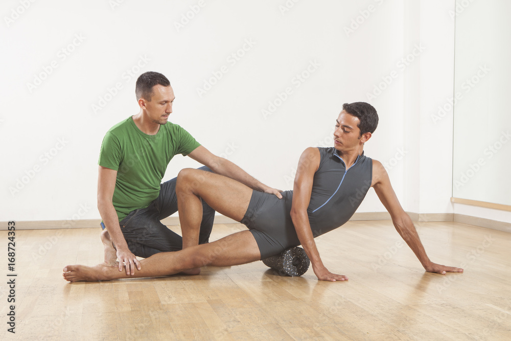 pilates instructor teaching a ballet dancer using foam roller pilates instructor teaching a ballet dancer using foam roller