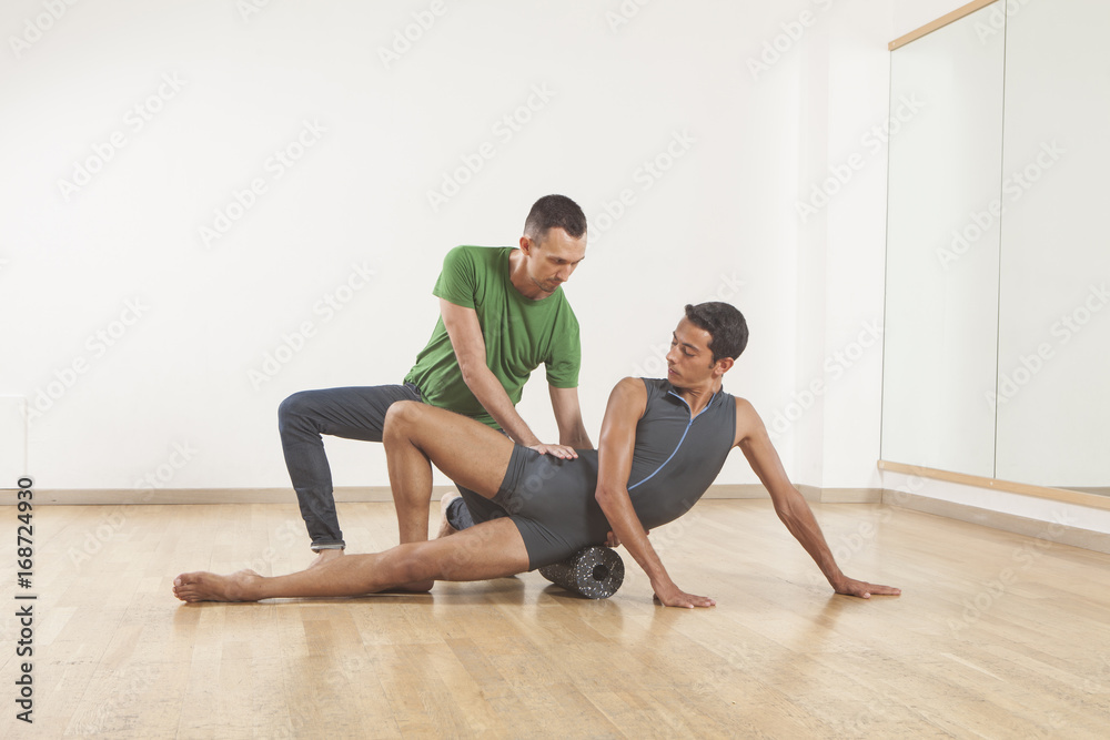 pilates instructor teaching a ballet dancer using foam roller pilates instructor teaching a ballet dancer using foam roller