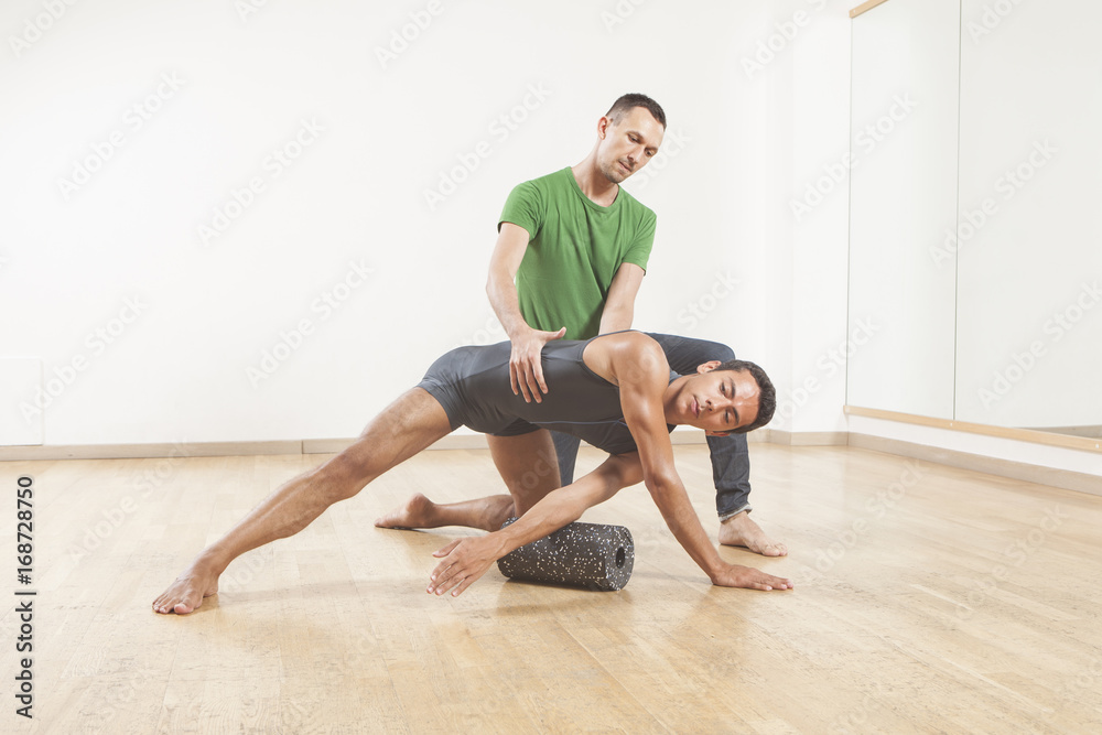 pilates instructor teaching a ballet dancer using foam roller pilates instructor teaching a ballet dancer using foam roller