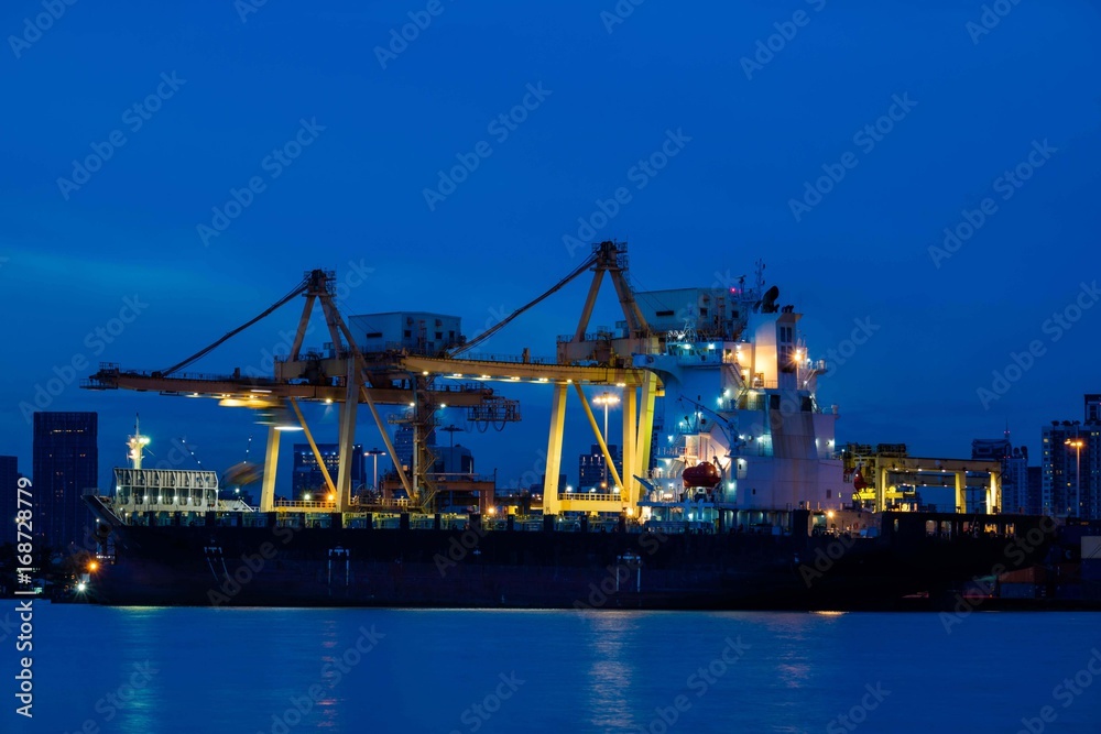 Container loading by crane, cargo ship at shipping port at twilight, Logistics and transportation concept Container loading by crane, cargo ship at shipping port at twilight, Logistics and transportation concept