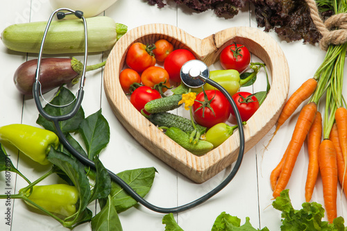 Fresh vegetables and heart on a white background