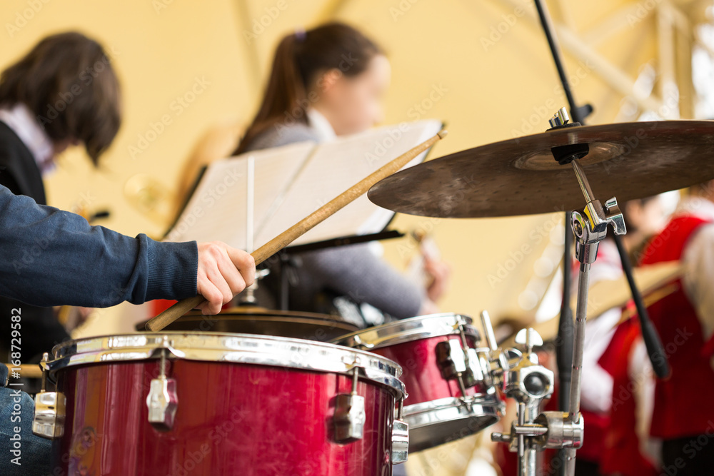 Obraz premium jazz band music performance concept - orchestra drum kit during the concert, closeup on hand of musician playing on percussion instruments and ride cymbal, selective focus