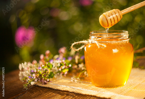 Delicious delicious honey in  jar on table