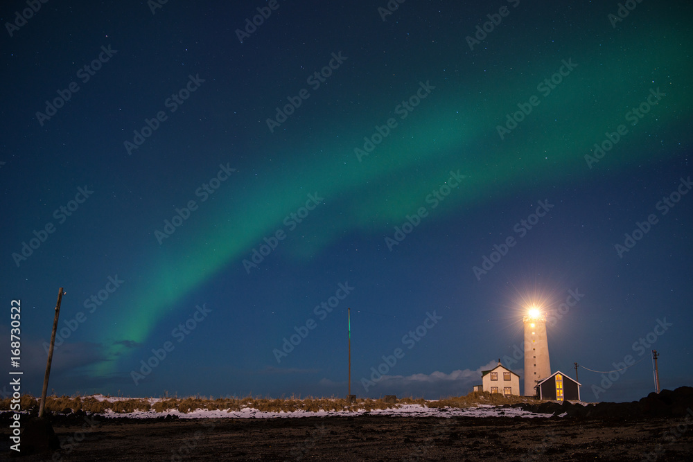 Northern lights or Aurora Borealis over the lighthouse near Reykjavik, Iceland