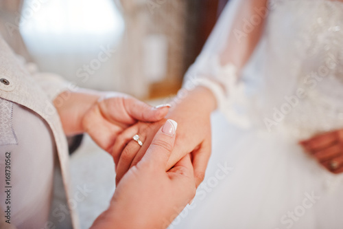 Close-up photo of a mother holding her daughter's hand on her wedding day.