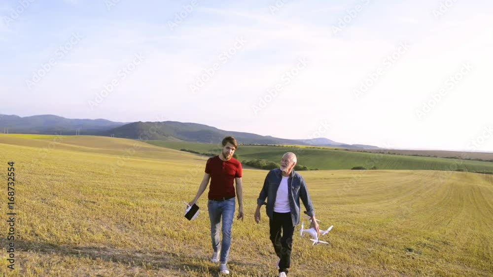 Senior father and his son with drone outdoors. Senior father and his son with drone outdoors.