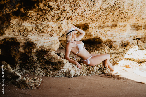 Beautiful blonde woman on cliff beach. Beautiful woman with fit body in sexy bikini, tropical cliff