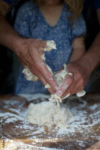 parent helping little girl to knead dough. preparation, messy, hands, flour.
