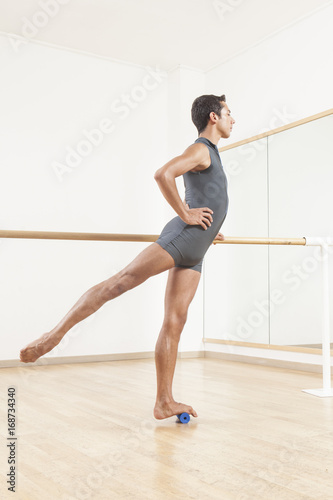 ballet dancer stretching and warming up using foam roller