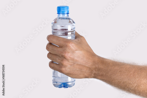 Close up man's hand Holding Bottle of  Water isolated on white background photo