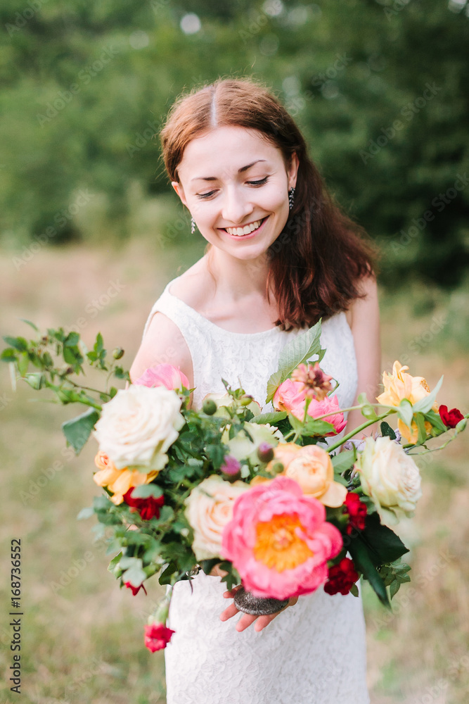 bouquet, people and floral arrangement concept - young woman look with a smile at bouquet of pink peonies, white and yellow roses, carnations and daisies, girl florist in white dress in the garden bouquet, people and floral arrangement concept - young woman look with a smile at bouquet of pink peonies, white and yellow roses, carnations and daisies, girl florist in white dress in the garden