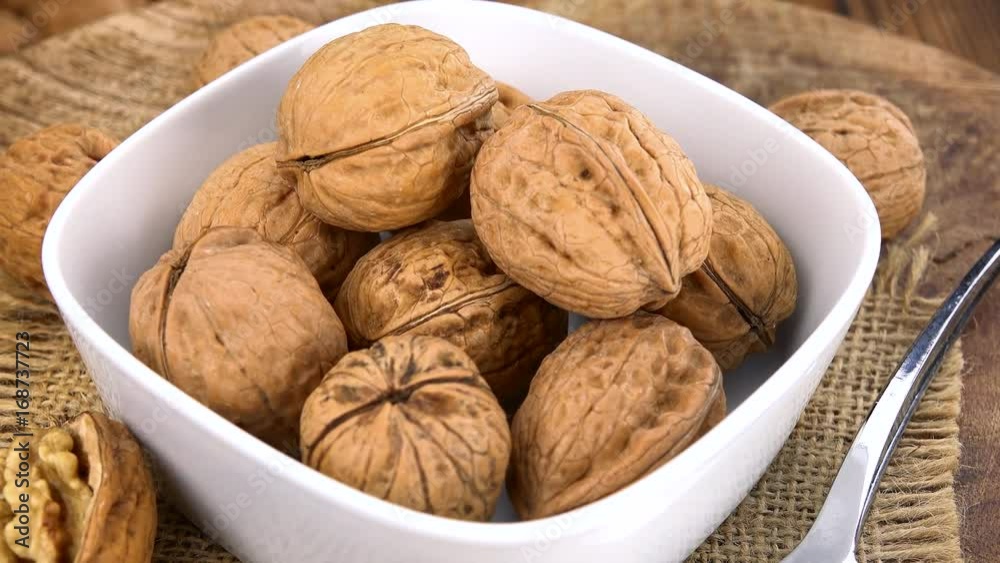 Portion of Walnuts rotating on a wooden plate (not loopale; 4K) Portion of Walnuts rotating on a wooden plate (not loopale; 4K)