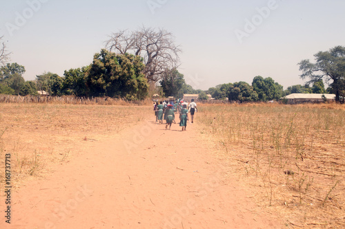 african kids coming back to school on a dirt road