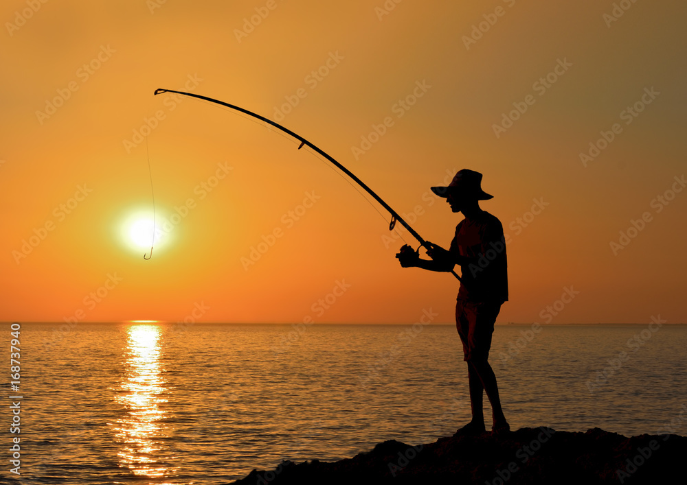 silhouette of man fishing in the sea