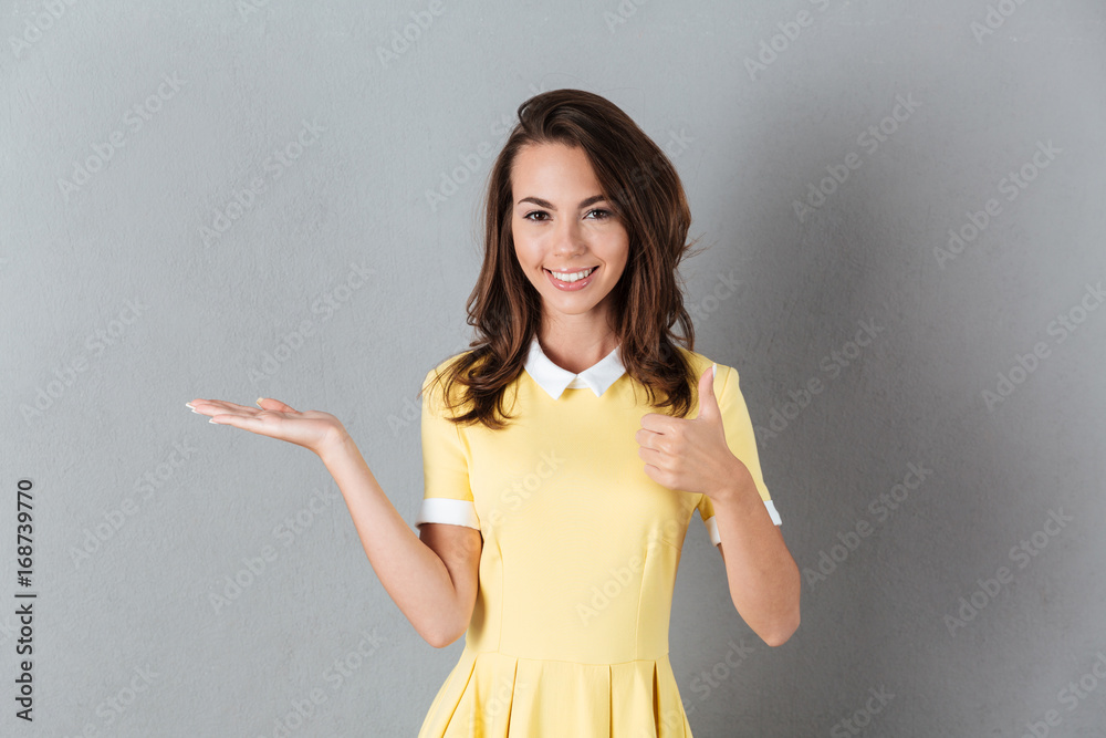 Smiling girl in dress holding copy space on a palm Smiling girl in dress holding copy space on a palm