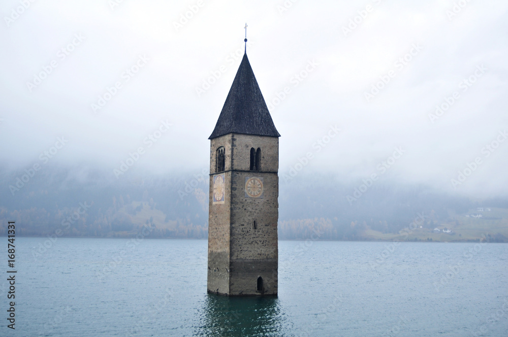 Submerged tower of reschensee church deep in Resias Lake of Bolzano, Italy