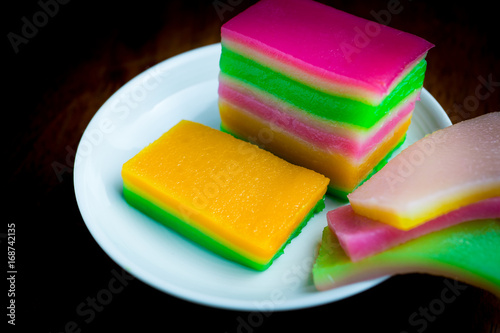 Asian snack, colorful rolling layer cake in white dish with black background