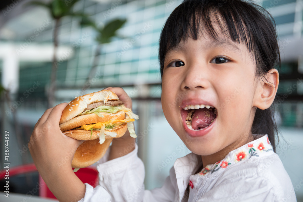 Asian Chinese little girl eating burger Asian Chinese little girl eating burger