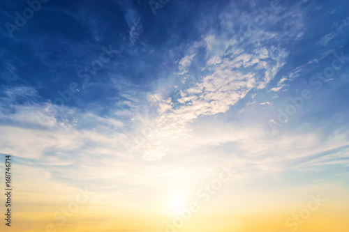 Sky background at sunset,Sky blue and orange light of the sun through the clouds in the sky © Sky Stock