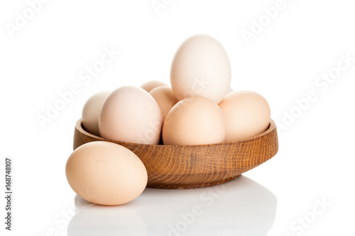 chicken eggs in a wooden plate isolated on white background