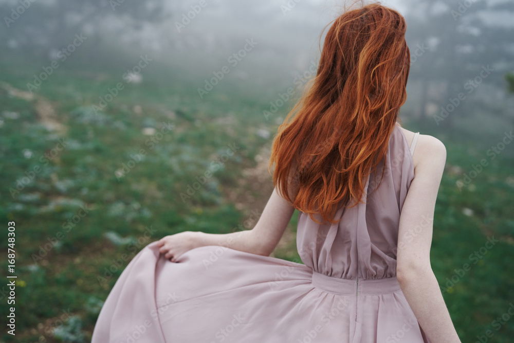 Beautiful young woman in a long dress in the mountains, fog Beautiful young woman in a long dress in the mountains, fog