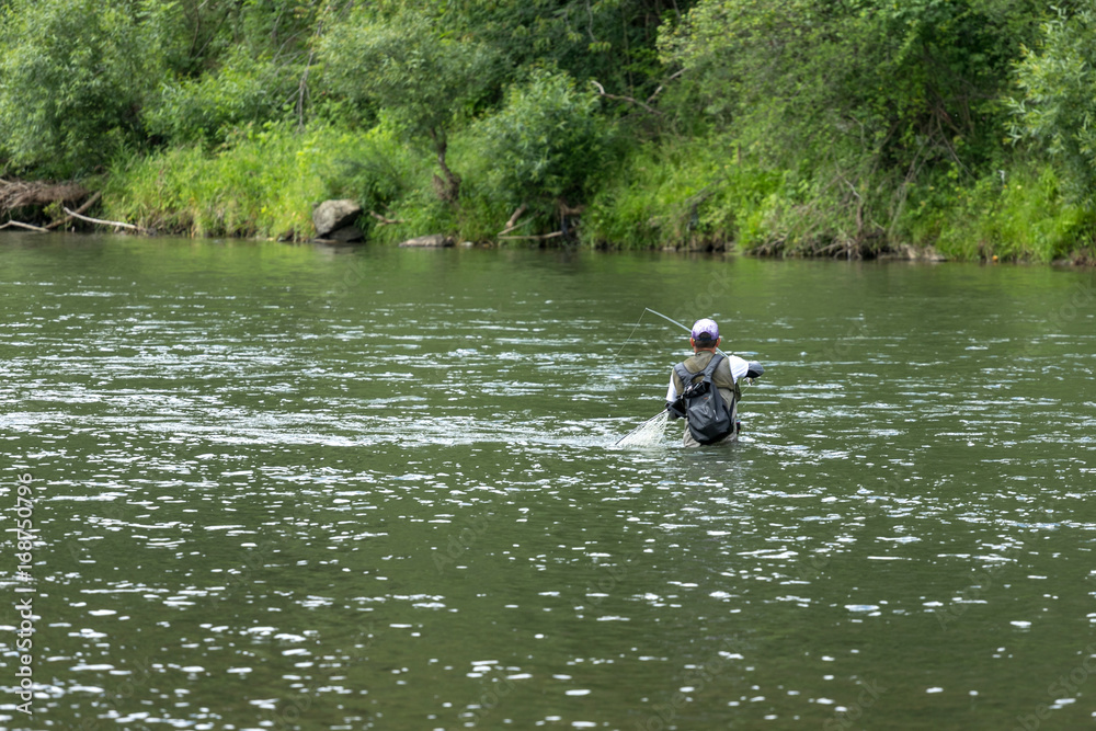 Fly fisherman flyfishing in river
