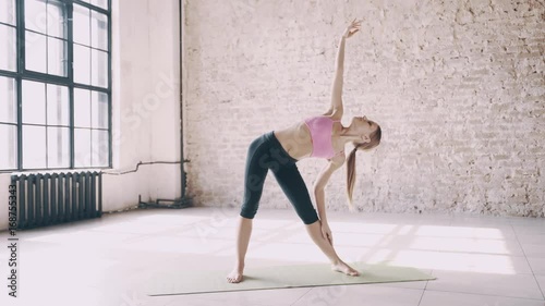 Beautiful yoga girl doing asanas in studio photo